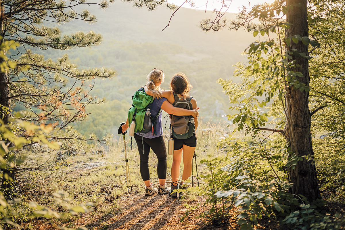 Mother and daughter hikers embracing each other